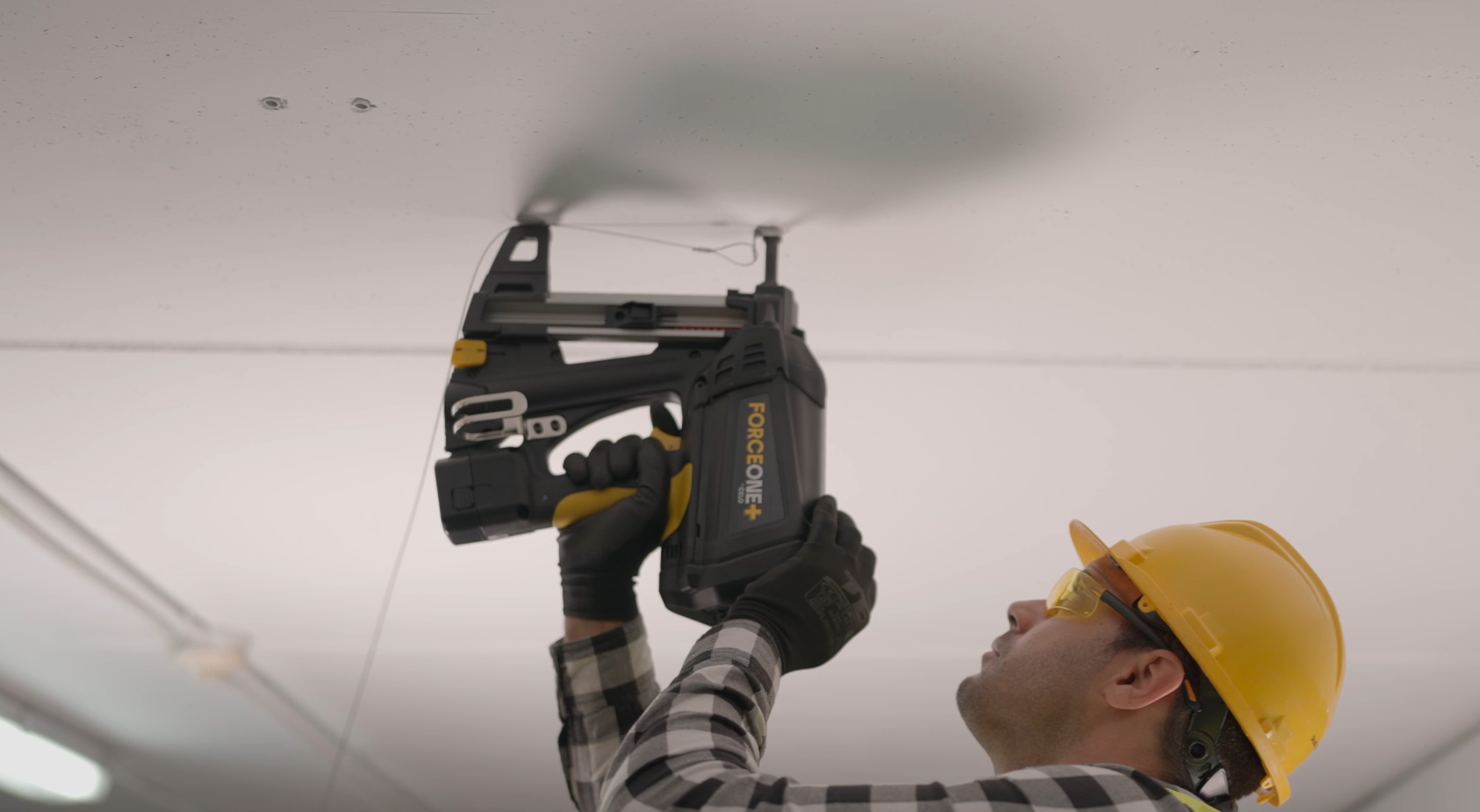 A contractor nailing the AWFS system to a ceiling with the FORCE ONE+